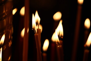 Poster - A group of lit candles in a dark room. Perfect for creating a cozy atmosphere