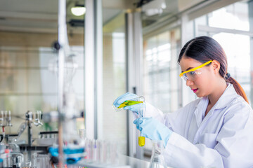 Wall Mural - attractive young asian scientist woman lab technician assistant analyzing sample in test tube at lab
