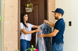 © AntonioDiaz - Joyful lady getting her clothes from a dry cleaning service  a plastic pouch from a courier at her doorstep