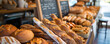 © Volodymyr - A bakery counter with an array of bread loaves, rolls, and baguettes, with a chalkboard menu in the background. Bright, warm lighting highlights the freshness.