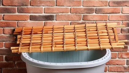 Wall Mural - a bamboo laundry board in a rubber tub against a brick wall