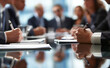 © Curioso.Photography - Business meeting with people writing on papers at a conference table.