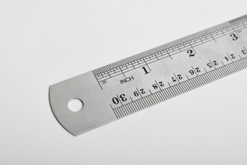 Iron ruler on a white background. Stainless steel ruler. Stationery and work tools made of metal steel. Selective focus, isolated on white background