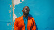 © Generative AI - fashion african man in sunglasses in trendy modern clothes posing against the background of a blue building on the street : Generative AI