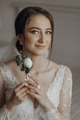 Wall Mural - A woman is holding a flower in her hand and smiling. The flower is white and green. The woman is wearing a wedding dress and a veil. Concept of happiness and celebration