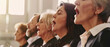 © Ai Studio - A group of adults singing in harmony during a choir practice, their faces lit by natural light streaming through large windows.