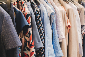 Poster - A rack of clothes with a blue shirt with a red and white design