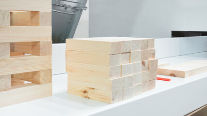Poster - A white counter top with a stack of wooden blocks on it. The blocks are of different sizes and are arranged in a way that they look like a puzzle. Concept of creativity and playfulness