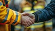 © Naret - Close-up of a handshake between a firefighter and another person, symbolizing teamwork, gratitude, and support in emergency situations.