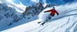 © Nuth - A skier in a red jacket carving down a snowy mountain slope under a clear blue sky with jagged peaks in the background during a sunny day.