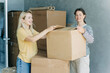 © Ilona - Happy women having fun while unpacking boxes and stuff while moving in a new home.