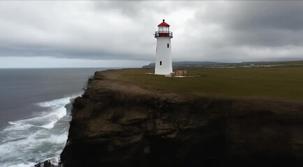 Wall Mural - Aerial drone shot of light house on a cliff near ocean 