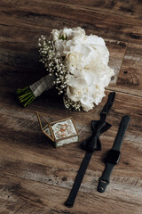 Wall Mural - A bouquet of white flowers sits on a wooden table next to a watch and a ring box