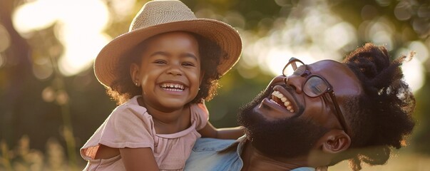 Wall Mural - Laughing young girl in a hat sits on her father's back