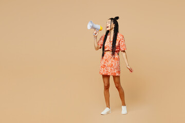 Wall Mural - Full body young Latin woman she wearing orange dress casual clothes hold in hand megaphone scream announces discounts sale Hurry up isolated on plain pastel light beige background. Lifestyle concept.