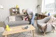 © Pixel-Shot - Young tattooed man fixing cushion on sofa at home