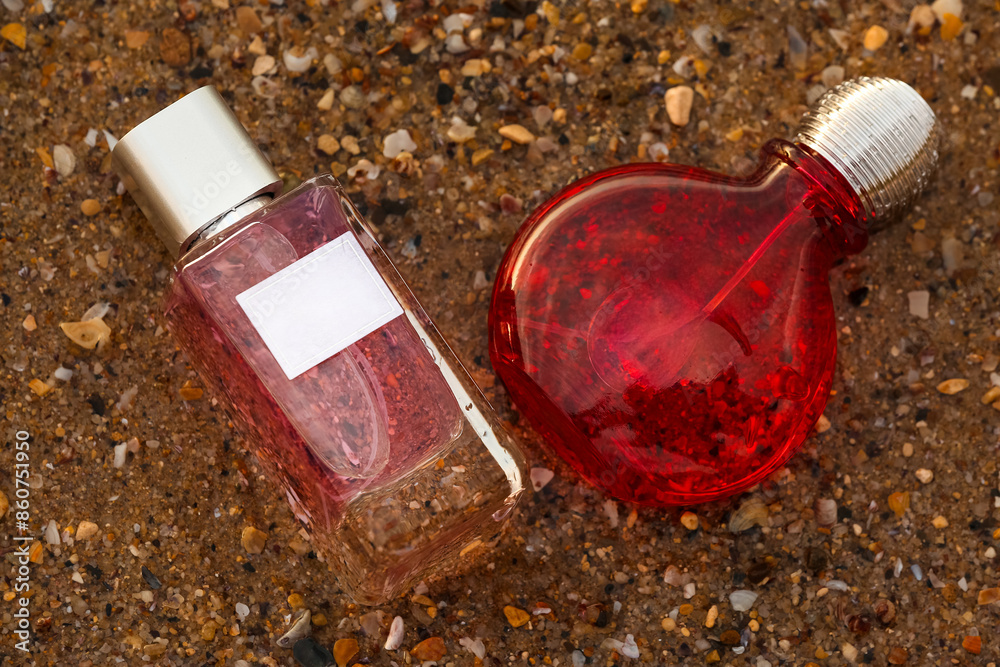 Bottles of luxury perfume on sand in water at beach