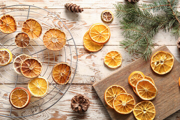 Wall Mural - Stand and board with dried orange slices on white wooden background