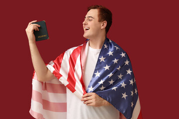 Wall Mural - Handsome young happy man with USA flag and passport on red background