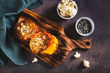 Poster - Keto burgers on cauliflower fritters with cutlet, tomato and cheese on a board top view