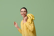 © Pixel-Shot - Beautiful young woman with sweet bananas on green background