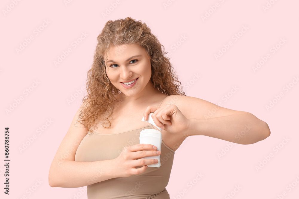 Happy young woman with deodorant on pink background