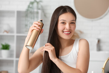 Sticker - Beautiful young happy woman applying hair spray at home