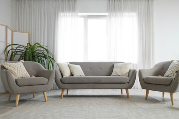 Wall Mural - Interior of stylish living room with comfortable sofa, folding screen, armchairs and carpet
