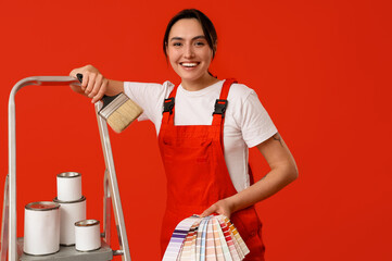 Poster - Female painter with color palettes, brush and cans of paint on stepladder against red background