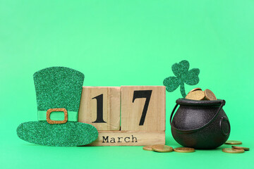 Wall Mural - Pot with golden coins, calendar and decor on green background. St. Patrick's Day celebration
