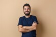 © Maxim Borbut - An attractive Caucasian man poses in front of a beige background with arms crossed