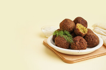 Wall Mural - Plate with delicious falafel balls and dill on beige background