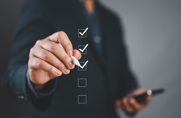 Poster - Businessman use pen to tick correct sign mark in checkbox for quality document control checklist and business approve project concept.