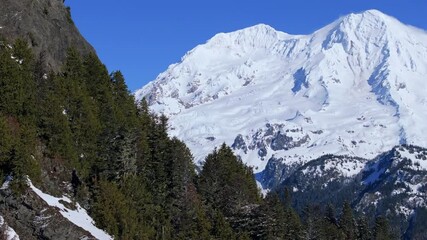 Wall Mural - Snow-Covered Mountain Peak with Evergreen Forest: Aerial View