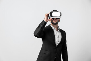 Caucasian business man planning financial plan while using VR goggle. Professional project manager standing and touching VR headset while using visual reality glasses to connect metaverse. Deviation.