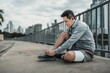 © Charnchai saeheng - A man tying shoelaces on sport shoes in the city center park before cardio workout, running.  Health and Lifestyle in big city life concept.