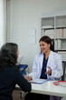 © crizzystudio - Confident Asian female doctor explains and questions a retired female patient attending a private clinic for treatment and therapy. Health concept, health insurance.