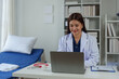 © crizzystudio - Expert Asian female doctor Professional and dedicated woman is working and reading medical research results on her laptop, studying medicine in office at hospital.
