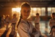 © Sourav Mittal - smiling girl in a karate outfit standing at the center of a dojo with many kids training in the background, golden hour light, high key color grading, soft shadows, low contrast, clean sharp focus, in