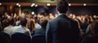 © StockKing - Symposium on business and entrepreneurship with a speaker presenting in a conference hall, featuring an unidentified audience member with a view from behind, against a copy space image.