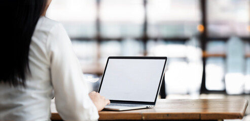 Fototapete - Cropped shot of woman hand working on laptop computer while sitting at the table. Mockup blank screen laptop.