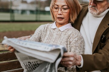 Sticker - Couple reading newspaper on park bench