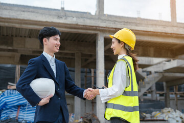 construction worker and contractor. Client shaking hands with team builder in renovation site in the morning.