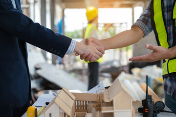 construction worker and contractor. Client shaking hands with team builder in renovation site in the morning.