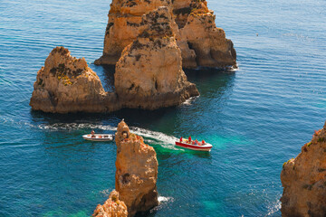 Beautiful coastline in Lagos, Portugal. Tourists boats