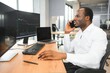 © Serhii - African-American broker works in office using workstation and analysis technology