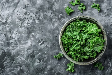 Wall Mural - Bowl of fresh green chopped kale on gray rustic stone background, top view, close-up. Ingredient for making healthy salad. Clean eating, detox or diet concept