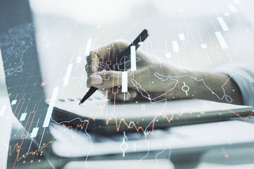 Poster - Double exposure of abstract creative financial chart with world map and with hand writing in notebook on background with laptop, research and strategy concept