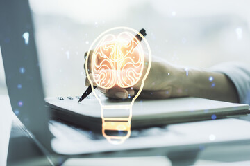 Poster - Creative light bulb with human brain hologram and hand writing in notepad on background with laptop, artificial Intelligence and neural networks concept. Multiexposure