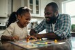 © Татьяна Евдокимова - Father and daughter are laughing and enjoying their time together while playing a board game at their kitchen table